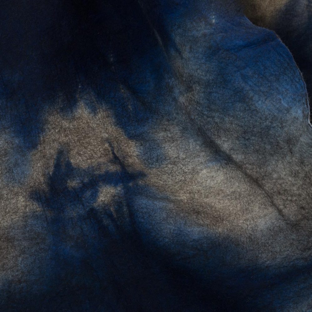 A piece of felt dyed blue and white, folded in a way that makes it look like a mountain or a wave crashing.