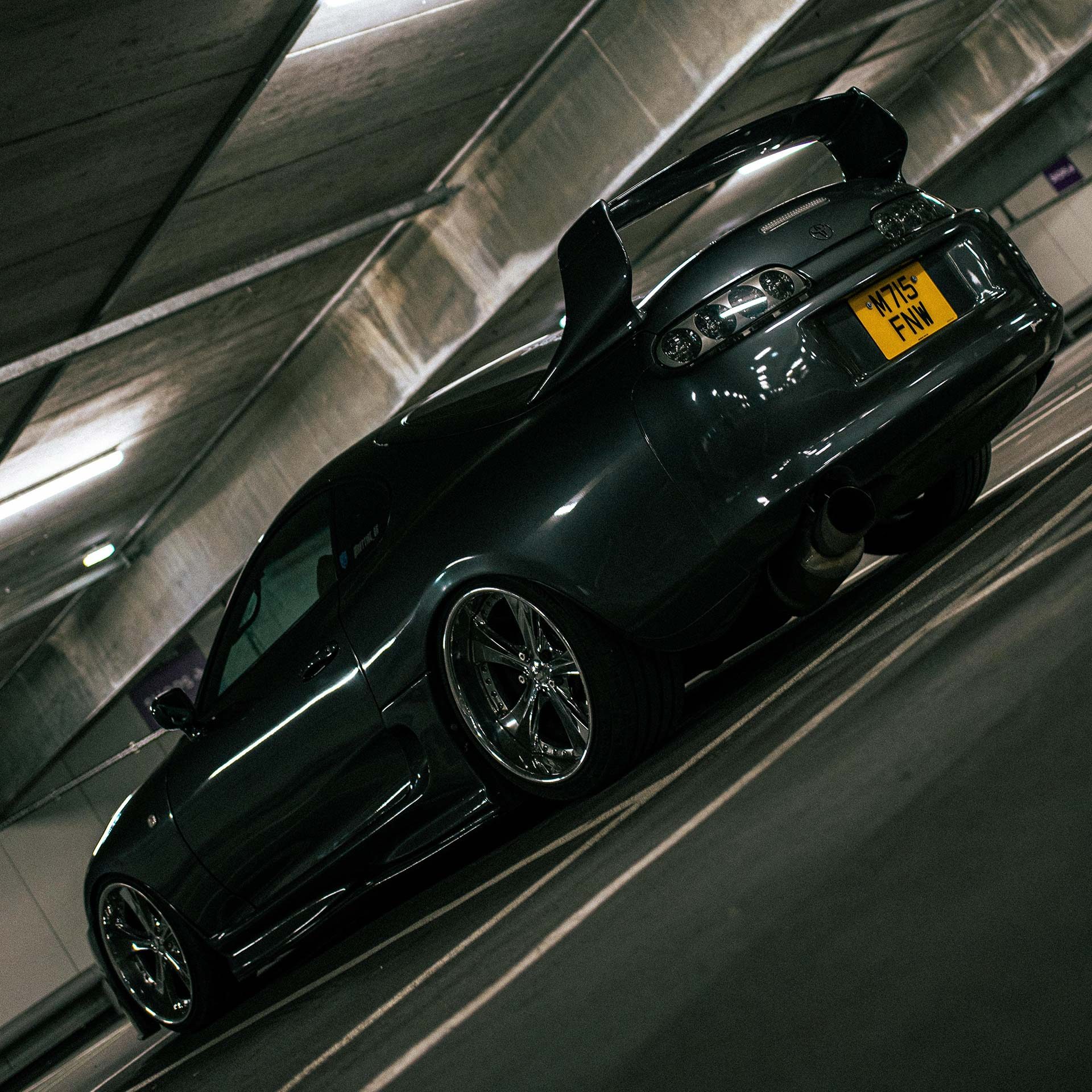 A black Toyota Supra with an oversized spoiler.